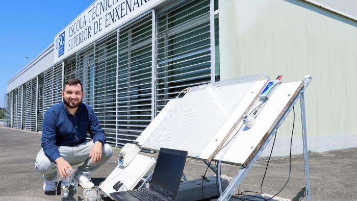 Jorge González co reactor que deseñou, construíu e operou empregando irradiación solar como fonte de luz, situado nunha terraza exterior da ETSE. Foto: Iria Lema