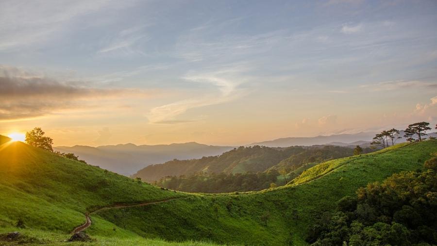 Unha investigación desenvolvida en Ciencias explora novas posibilidades en autoabastecemento enerxético e o aproveitamento da enerxía fotovoltaica. Foto: Pixabay Posta de sol nunha paisaxe verde